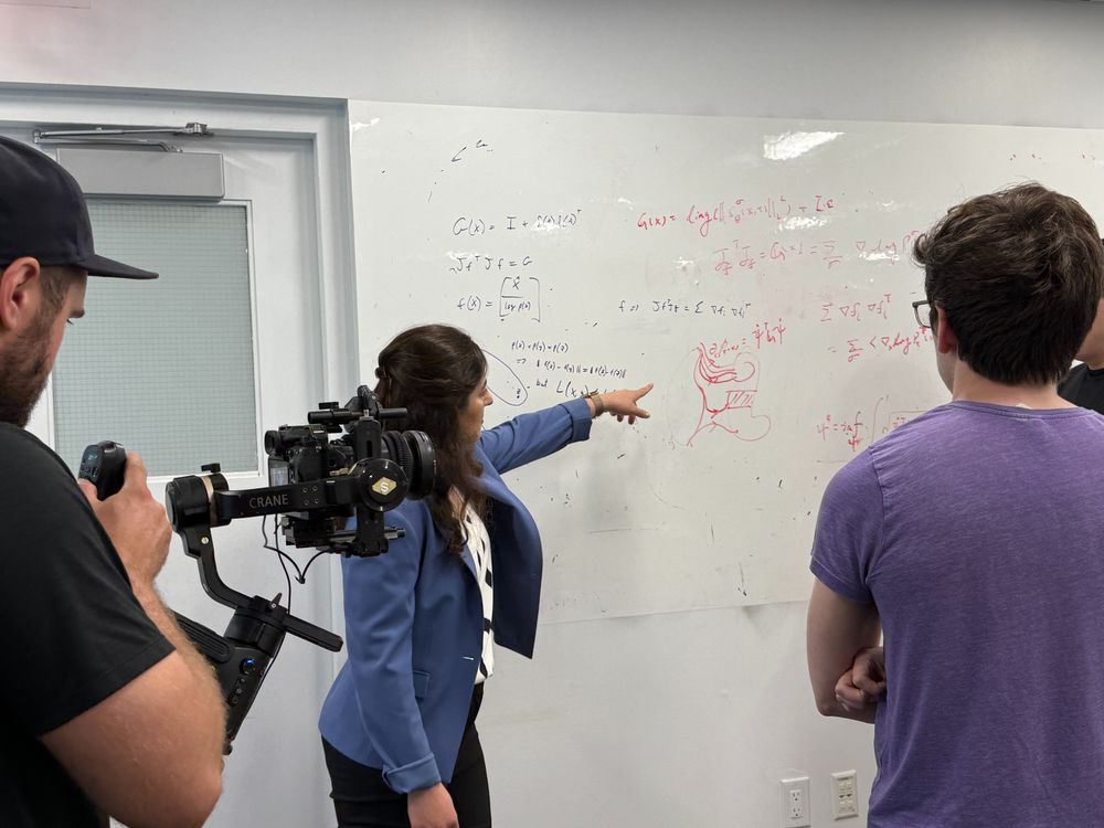 Elham Azizi pointing to a white board