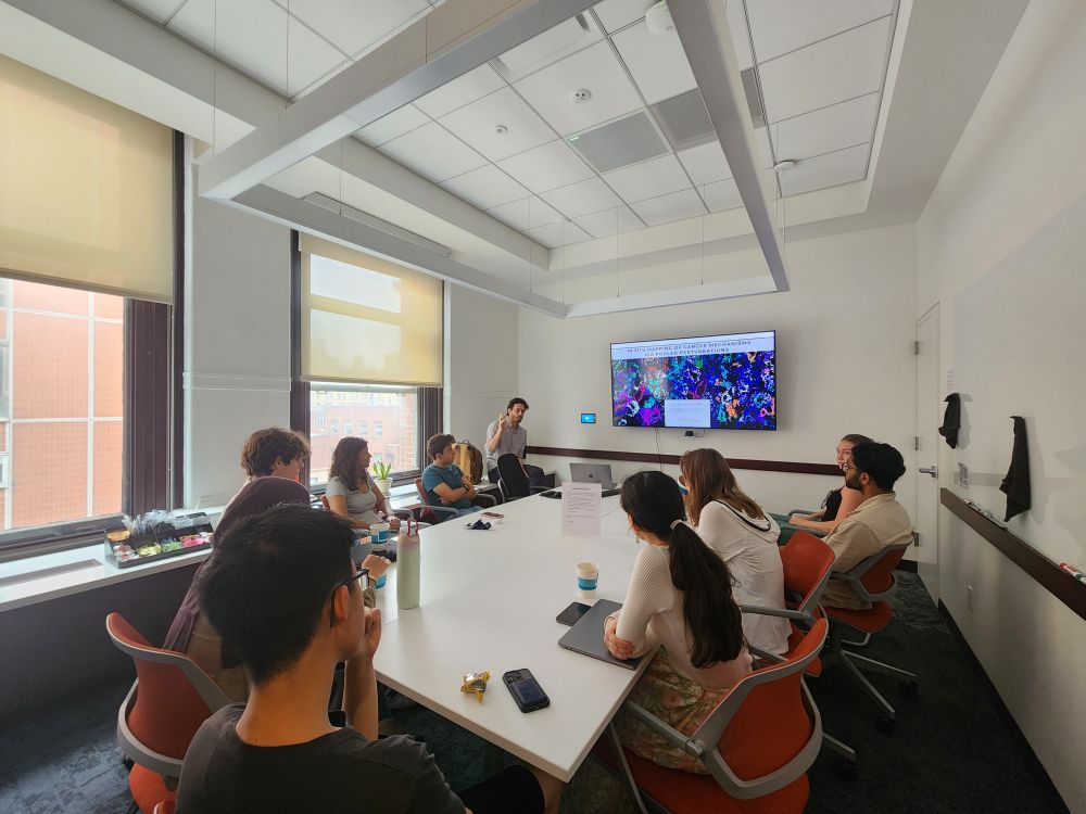 interns and seminar speaker sitting and discussing in a conference room
