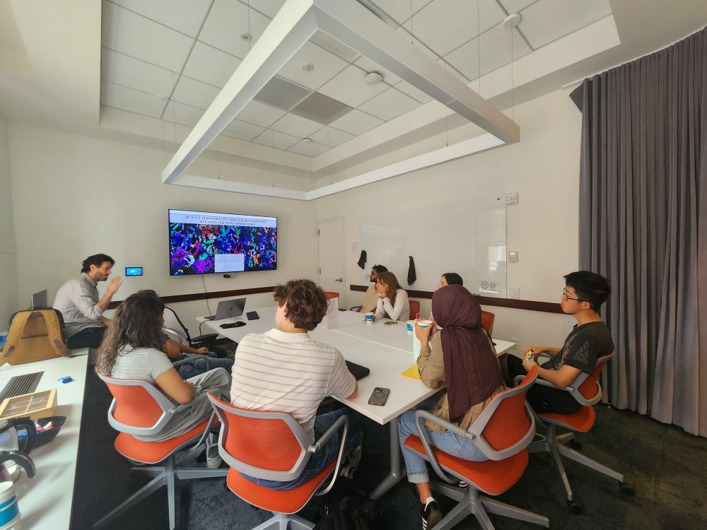 interns and seminar speaker sitting and discussing in a conference room