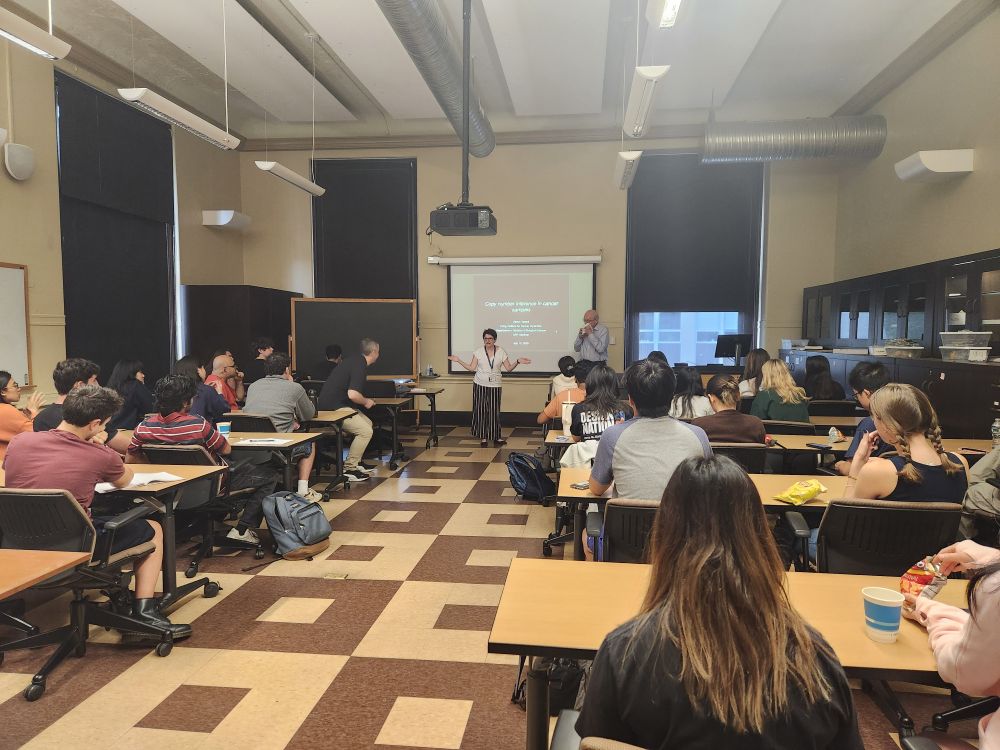 Three people presenting in front of a classroom
