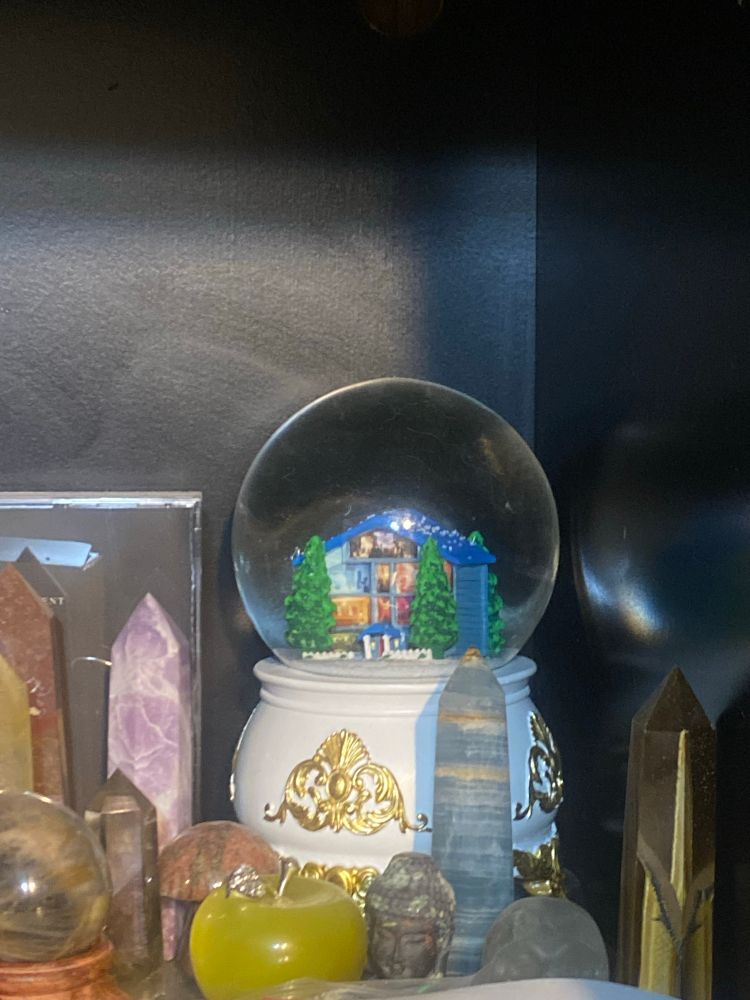 lover snow globe on a shelf with some crystals 