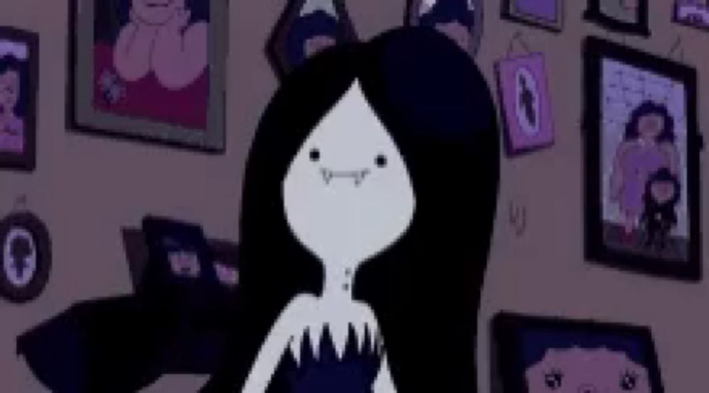 a cartoon character with long black hair is standing in a room surrounded by pictures .