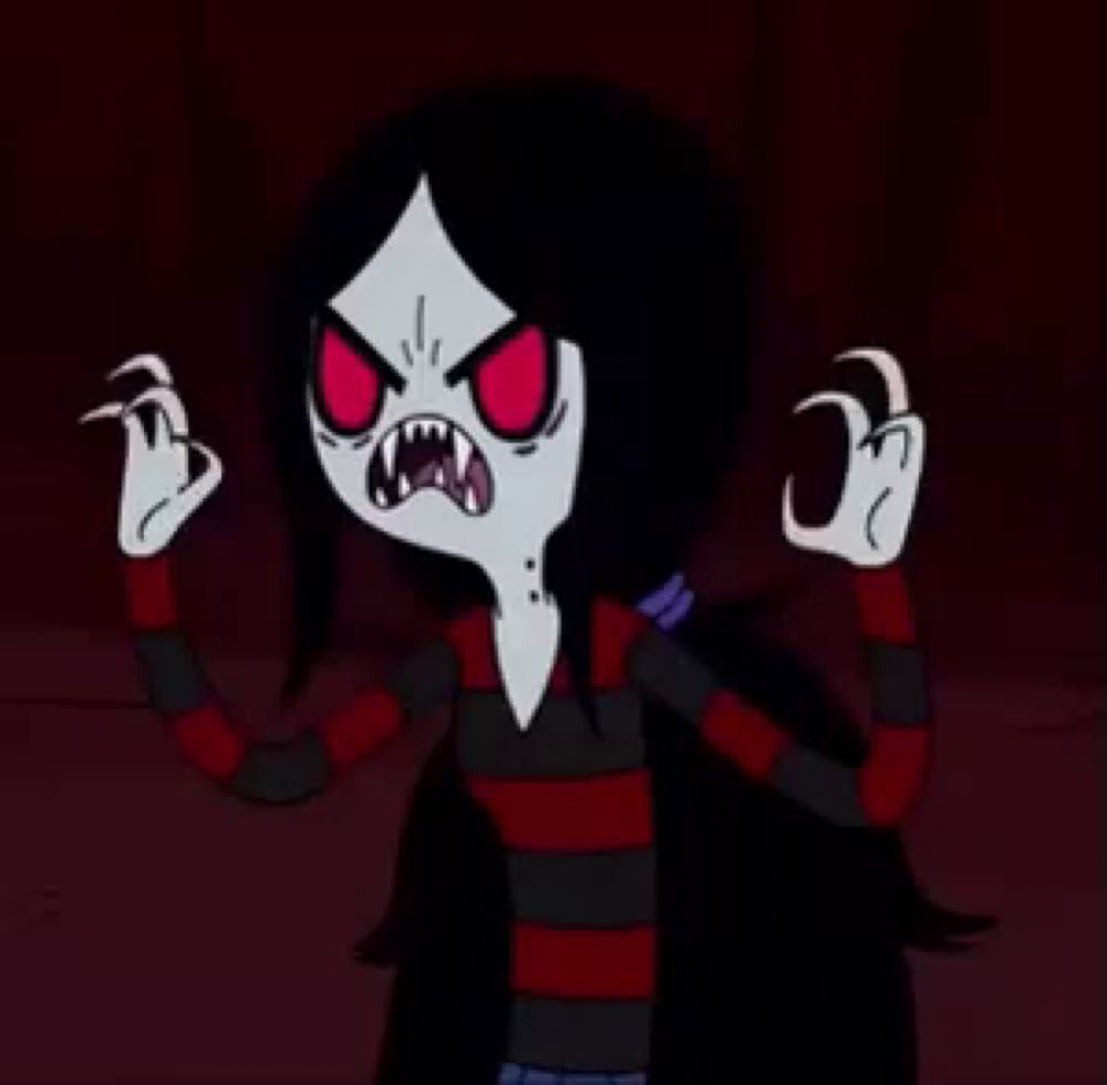 a cartoon character with long black hair and red eyes is making a funny face and giving a middle finger .