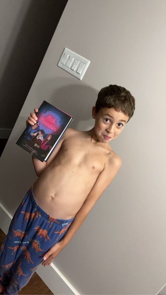 Link is tall and skinny like a fence post. He is wearing PJ bottoms and holding my newest book in one hand. His smirk is silly.