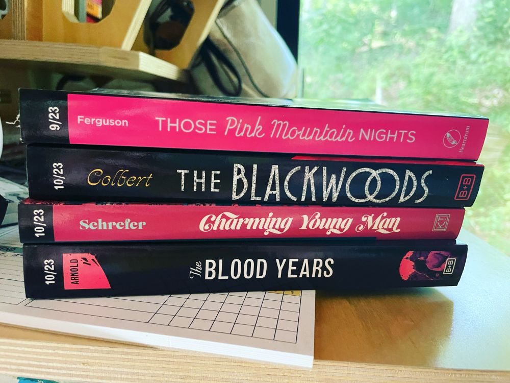 A stack of 4 ARCs. They all have pink on their spines.