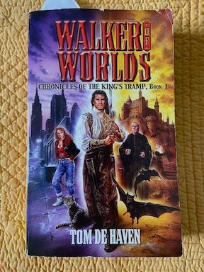 Book cover background: Left half an image of a modern city at night with a red-haired young woman in 1980s garb and styles staring out, a hissing cat in the foreground (the character in the narrative is actually blond).
Right half is a castle in daylight with a priestly old man and 2 flying bats, open mouths hissing, in the foreground.
In the middle is a man with long hair and colorful renaissance clothes holding a sword upright.
(all figures described are caucasion)
Tilte at top over images: Walker of Worlds
Subhead: chronicles of the King's Tramp, Book 1
Author's name at bottom: Tom de Haven
