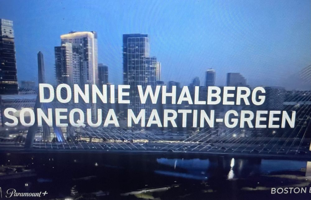 The names DONNIE WHALBERG [sic] and SONEQUA MARTIN-GREEN in while all-caps over an image of the Boston skyline, from a promo for the CBS series BOSTON BLUE 