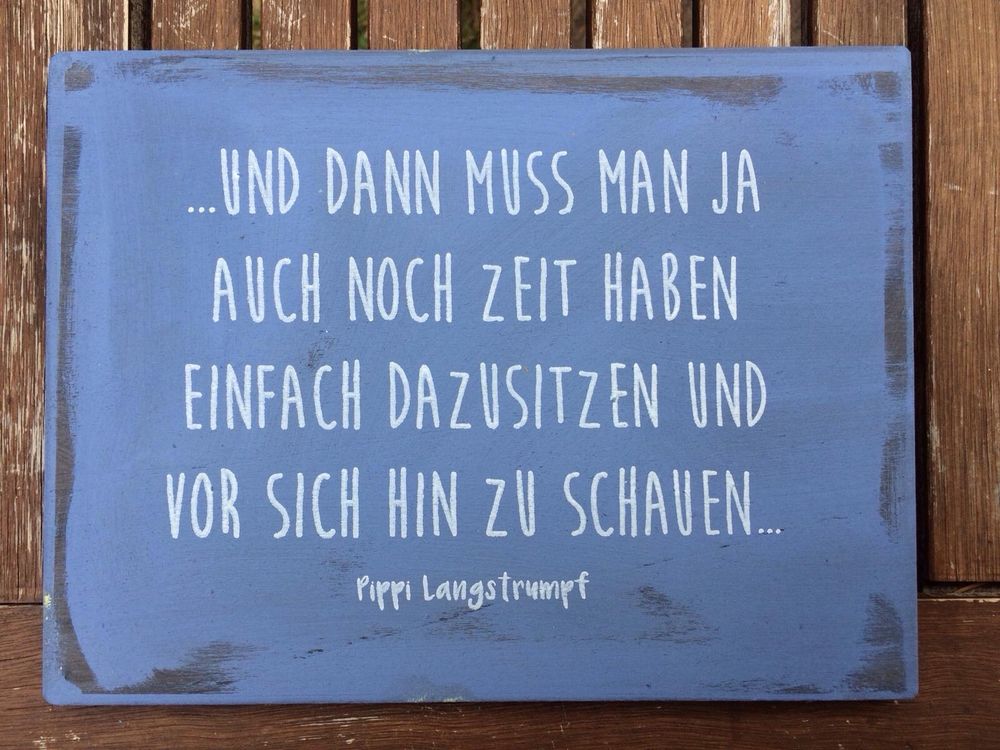Ein blaues Schild mit weißer Schrift darauf steht ein Satz von Pippilangstrumpf.