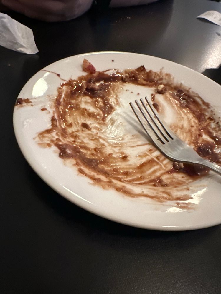 Photo of a plate that’s all nasty with chocolate and caramel leavings, nothing left but that and a fork. 
