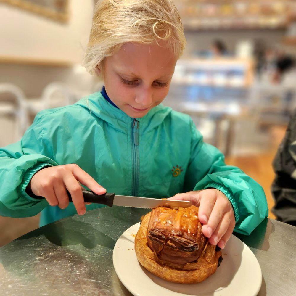 Kid 2 eating a giant chocolate croissant