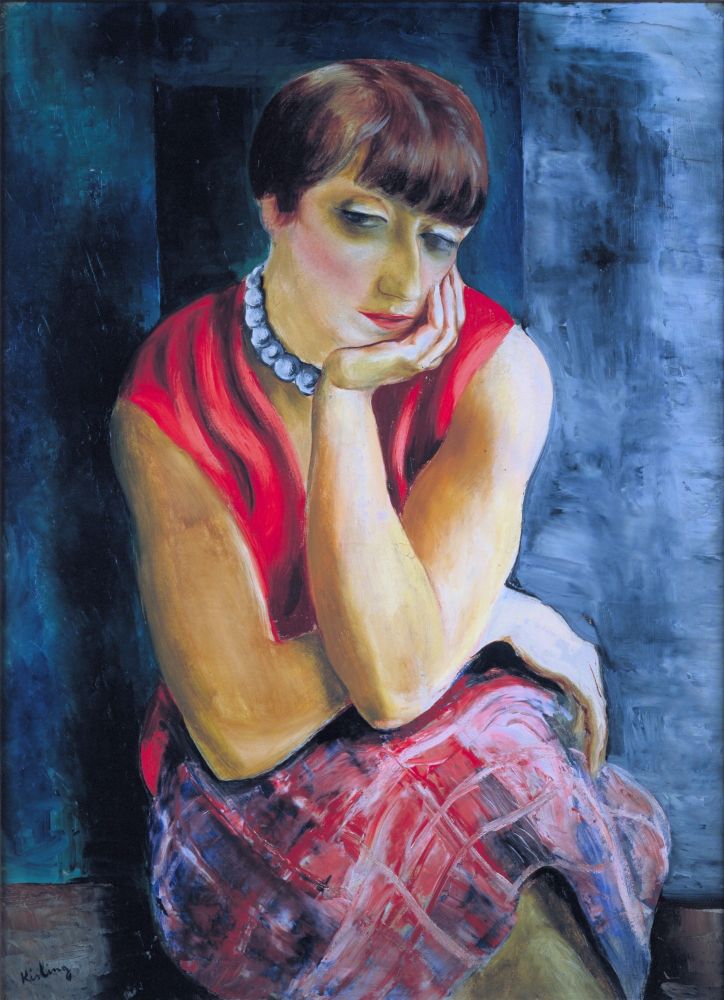 Among the French and émigré artists of École de Paris, many of whom where "cursed" by a life of repeated dissipation to die tragically under appreciated and suffering from poverty, painter Moïse Kisling could be called an exception.

Born in Poland, he came to Paris when he was 19. After two years, he already had contracts with art dealers and was living well. Known as cheerful and open-minded, Kisling gained many friends, and became a central figure in the nightly festivities of Paris, and was even called "King of Montparnasse." One year before this portrait was painted, his first solo exhibition was a great success and secured his fame.

The model in this painting is his spouse, Renée, whom he married five years before. She often posed for her husband. This work was completed around the time Kisling started to establish his own style of painting. 

Emphasis on volume, a simplified background plus a smooth and silky quality all speak undoubtedly of the beginning of the Kisling style. It is said that the couple enjoyed a happy married life filled with mutual understanding and trust. "The blessed painter" Kisling was apparently also a good husband and father.

Renée has short, dark brown bobbed hair, styled in a fashion typical of the early 1920s. Her face is pale with subtly rendered features, and her expression is one of quiet contemplation. Her eyes are downcast, and her mouth is gently closed in a neutral expression. She rests her chin on her hand, cradling her face. 

She wears a vibrant, loose-fitting red sleeveless bodice, which contrasts against her pale skin. Her skirt is a blend of reds, blues, and purples, with a plaid pattern, painted in a loose, impressionistic way. Around her neck, she wears a thick strand of elegant pearls.

The background is a deep, moody blue, painted with visible brushstrokes suggestive of depth and texture via darker and lighter areas, creating slight variations in tone.