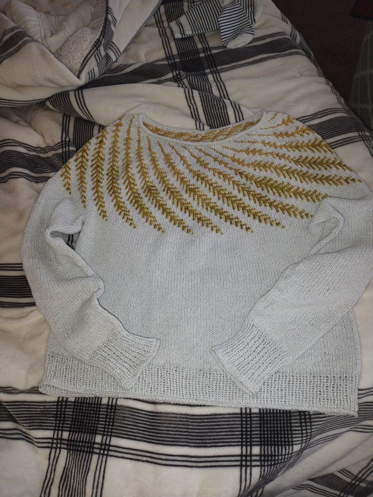 Avena in a light gray wool with a golden gradient colorwork yoke.