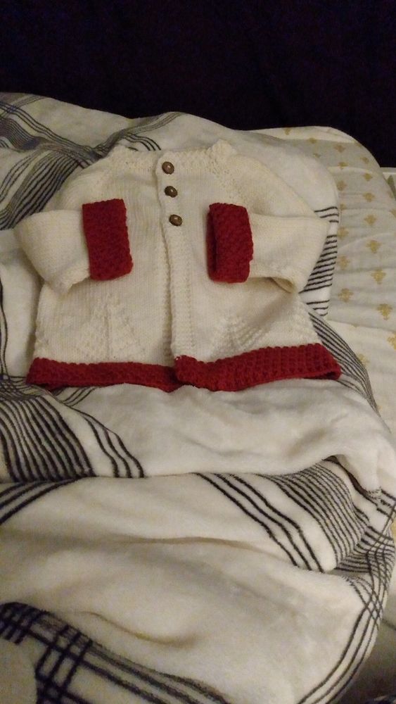 White cashmerino sweater with ruby hems. A raised tree design decorates the bottom border.