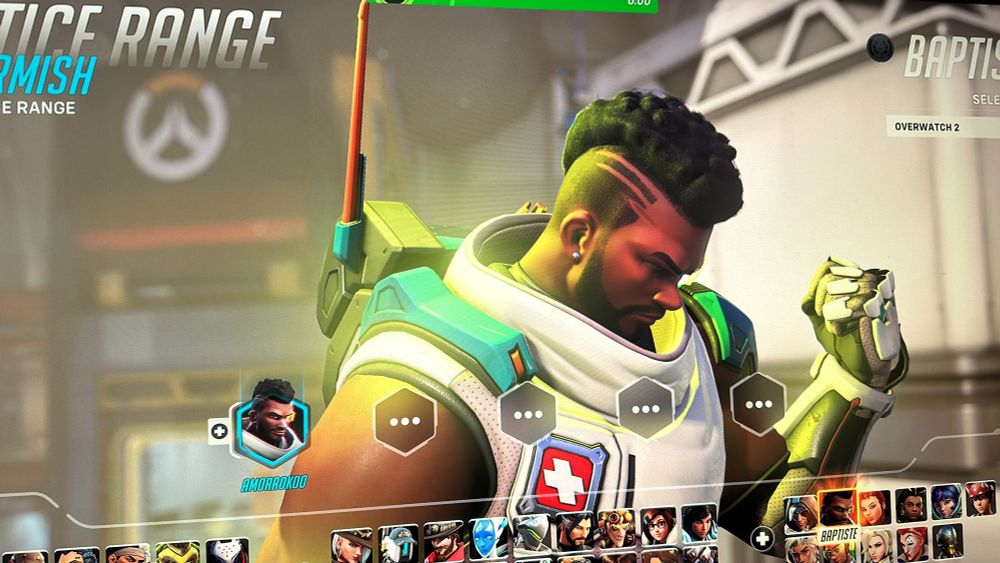 Picture of the overwatch 2 game character called Baptiste. He’s Black with a Mohawk and two lines shaved next to the Mohawk. He is making a fist and curling his bicep and looking down with his eyes closed. He is wearing a white vest. On the left breast of the vest is a badge of a white cross with a red background. He has these blue shoulder pad like things. My username amorrokko is showing above his player icon indicating I have selected his name. 