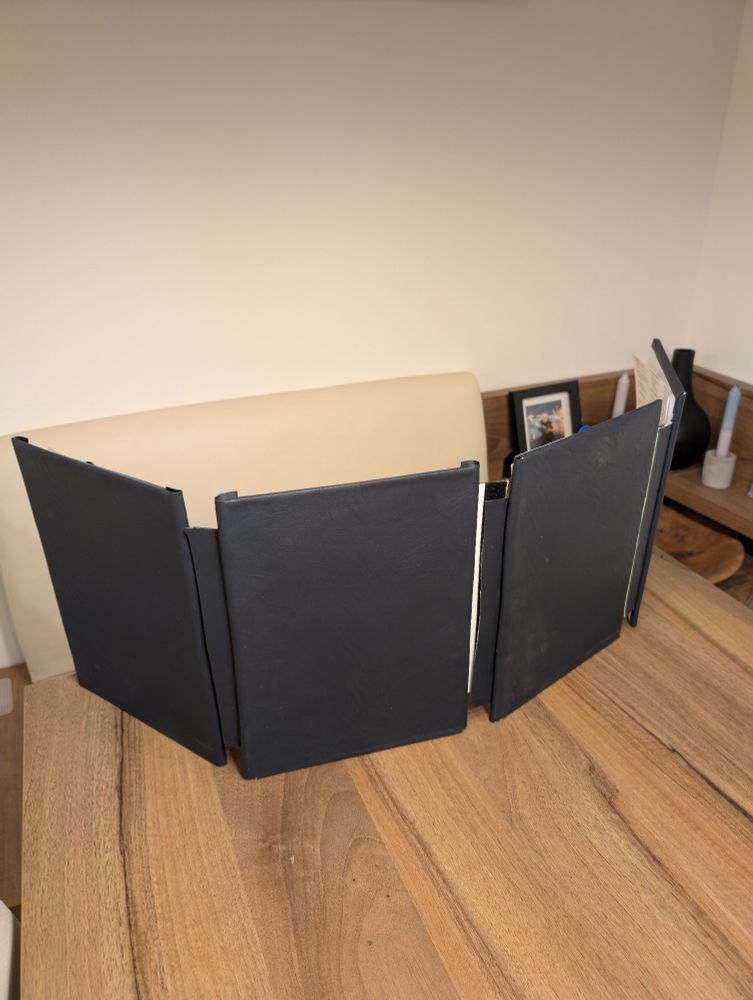 Player facing side of a DM screen with a dark blue fake leather cover