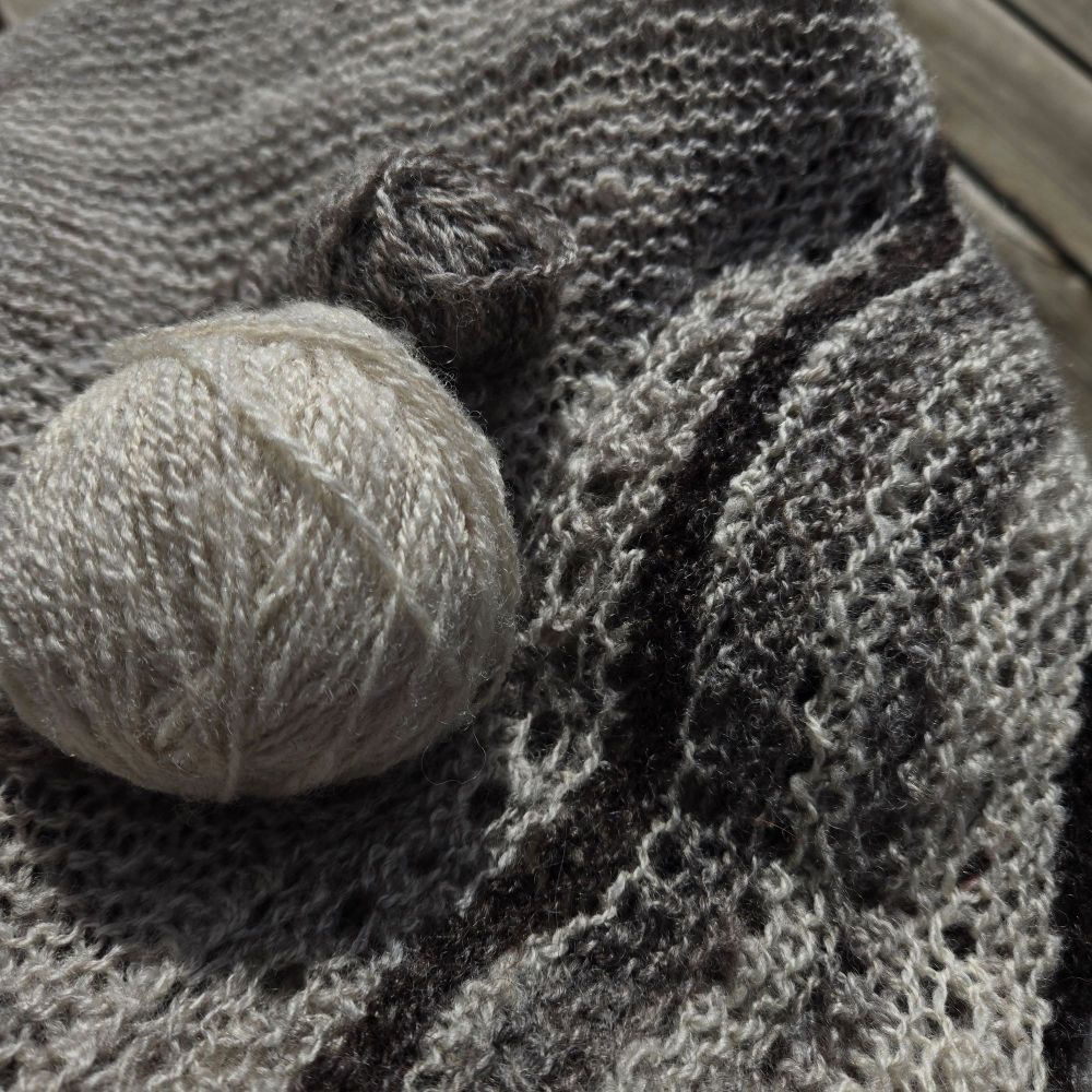 Grey wool spun (two small balls of yarn) and knit as a shawl