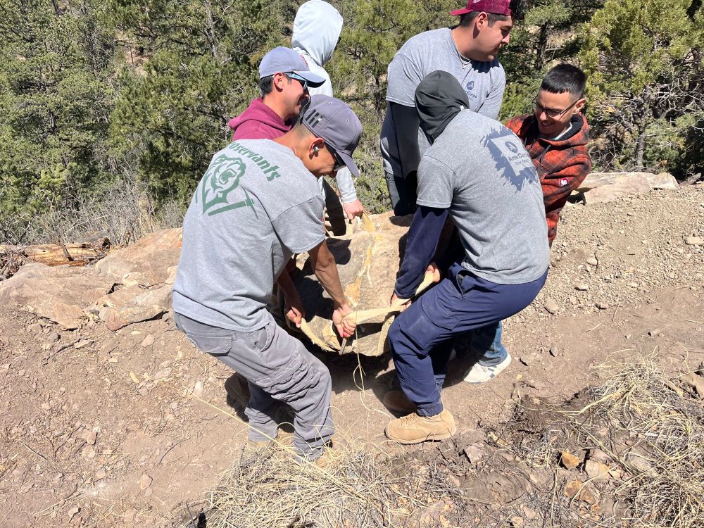 Crew moving a couple of 
hundred pound rocks with a rock slinge
