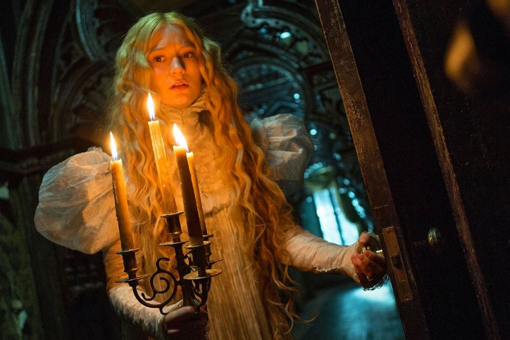 still from crimson peak of edith holding a candelabra looking concerned