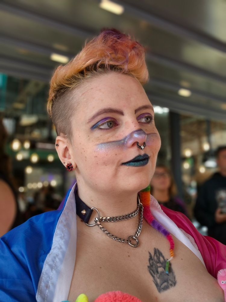 A selfie of a ginger person wearing a martingale collar at a pride parade