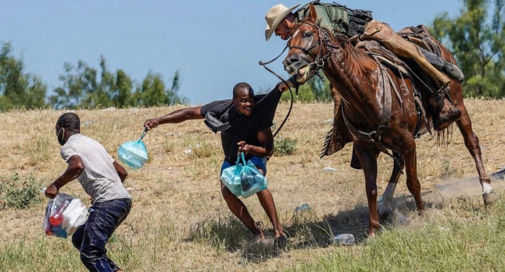 White man on horseback ropes black man 