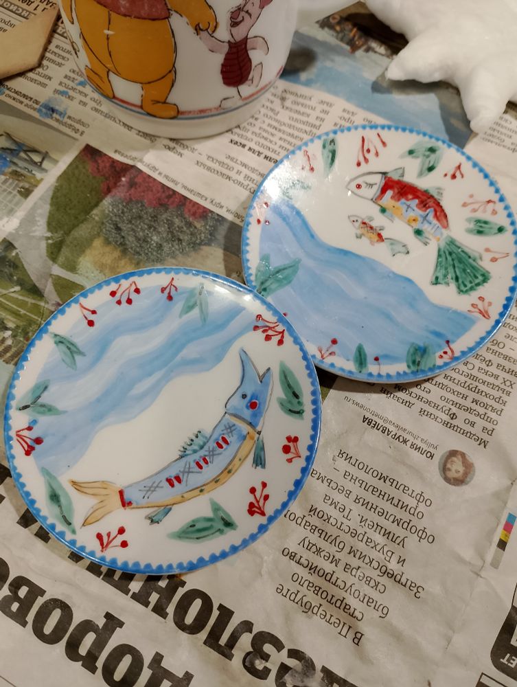 два маленьких блюдца с рыбами. на одном две рыбки, на втором щука. по краям ягодки