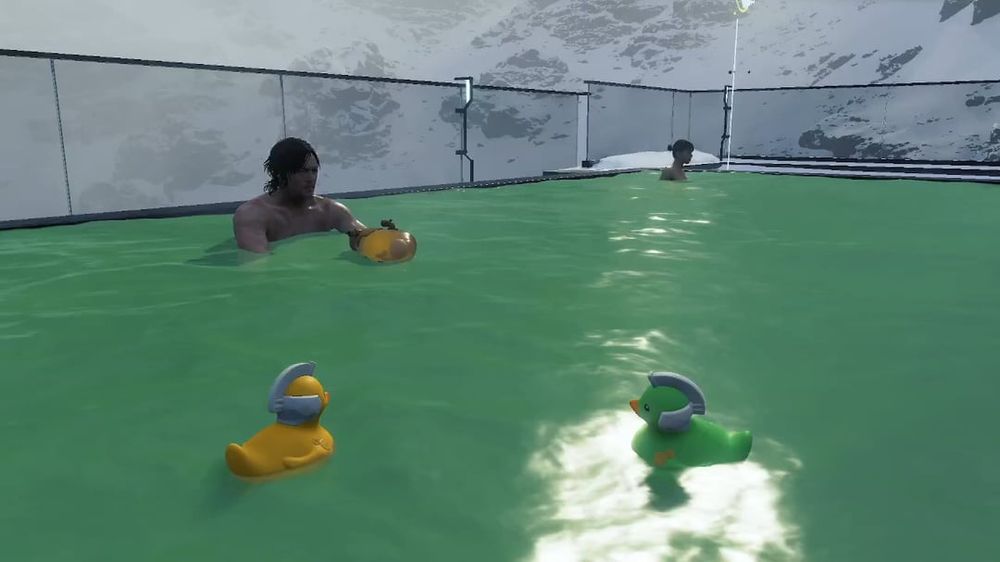 Sam and the Chiral Artist sitting in Hearthman's hot spirng far away from eachother, with two ducks one yellow, one green.