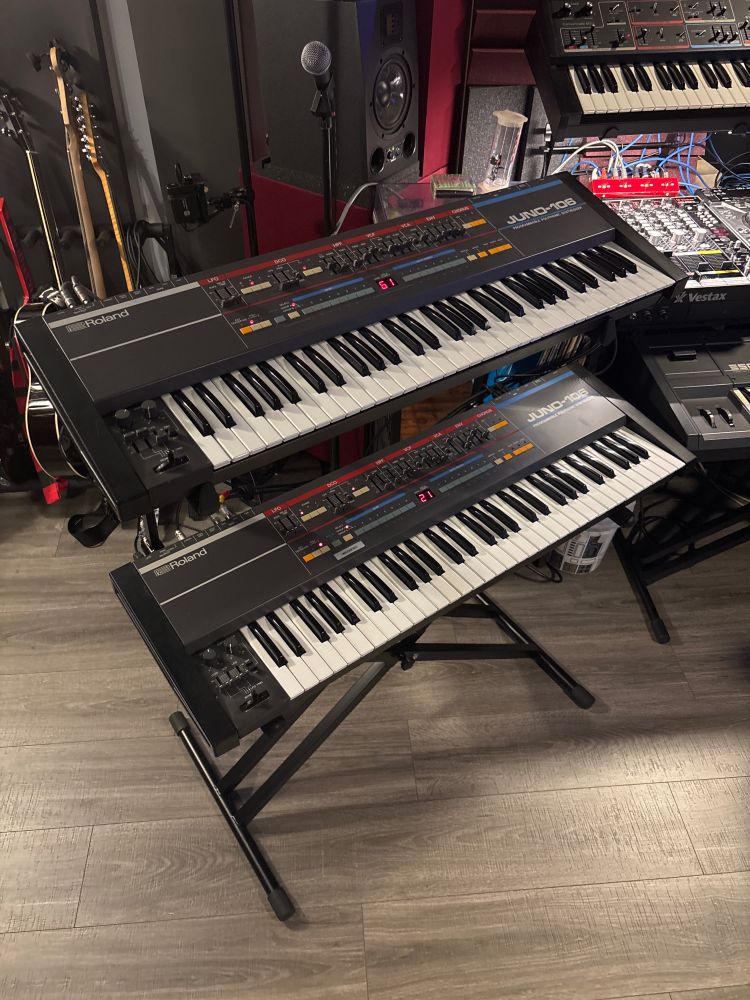 A photo of 2X Roland Juno-106’s on a double tier keyboard stand. In my lifetime I never would have thought to have two of these in my possession. Mine was repaired a few months ago brought back to life and a friend Repair was just completed today. The Sound that comes from these keyboards is unbelievable!