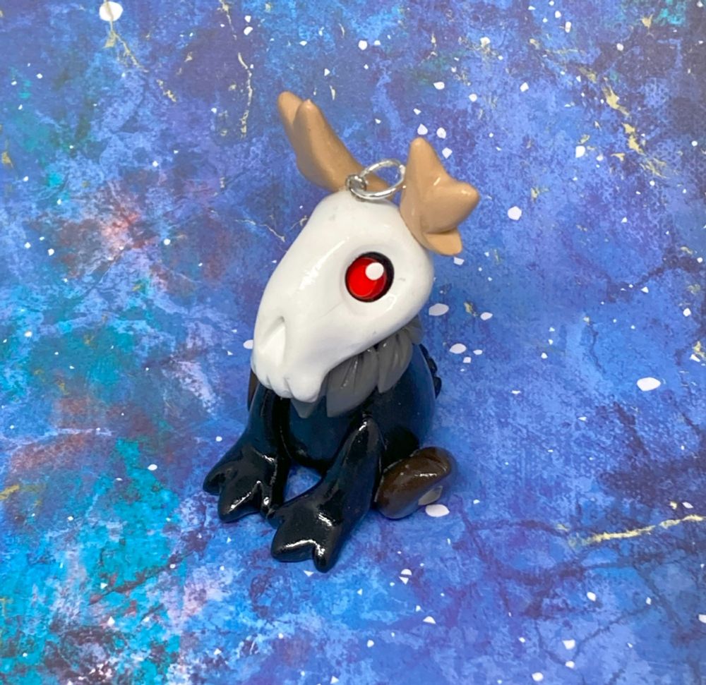 Photo of a polymer clay ornament of the cryptid Deerman facing 3/4 view towards the camera.