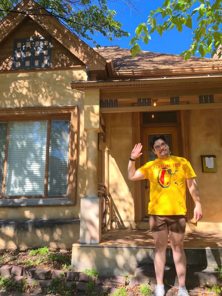 Nick from Broken Record waving in front of a house