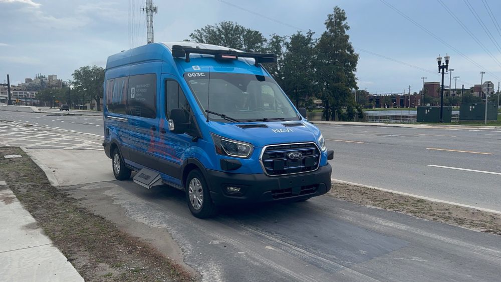 A NAVI "autonomous shuttle" near the future Four Seasons Hotel in Jacksonville. The Beep employee who must be constantly prepared to take over is in the driver's seat.