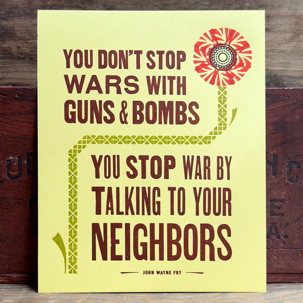 A yellow print with a flower that says ‘you don’t stop wars with guns & bombs. You stop war by talking to your neighbors’ said by John Wayne Fry. 