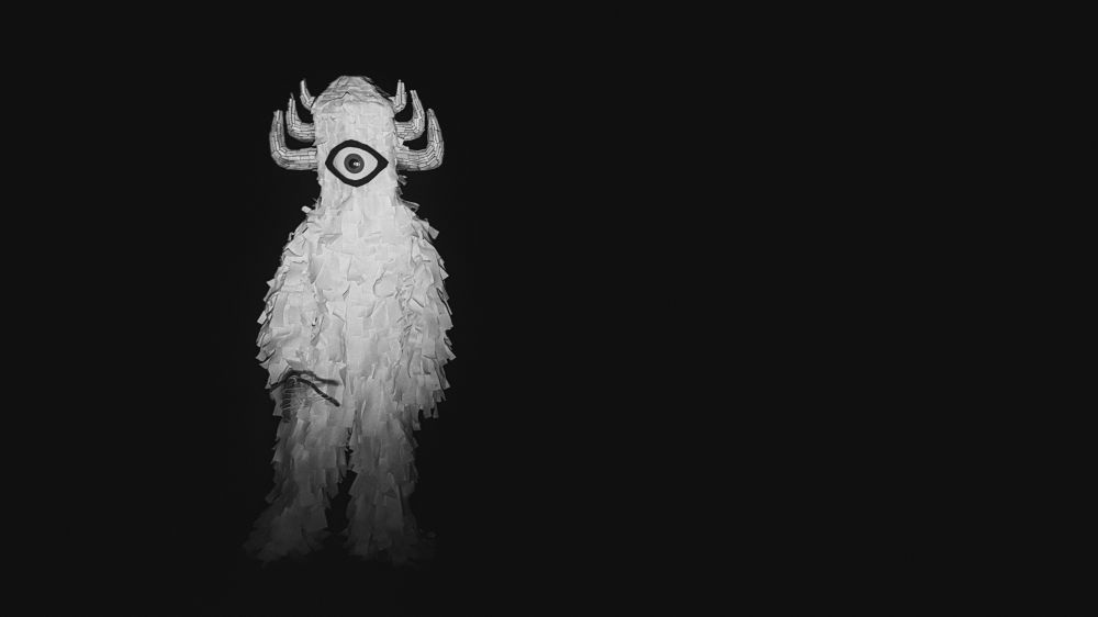 A creature designed by Torin Langen stands on an empty dirt road