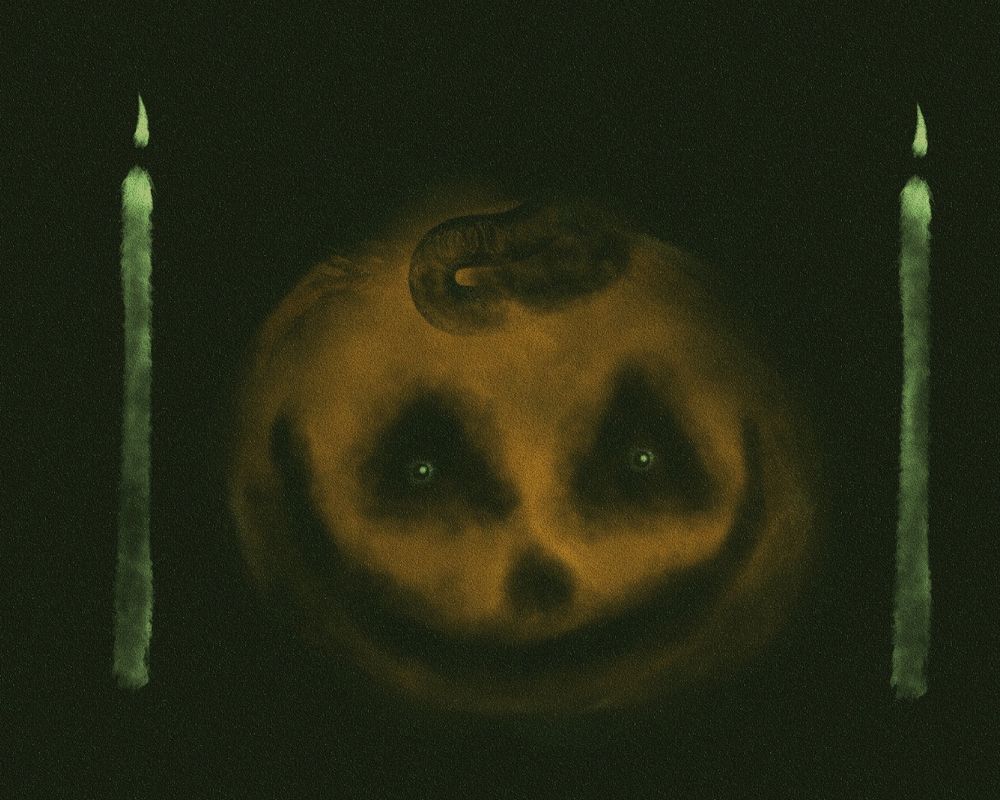 A pumpkin between two candles