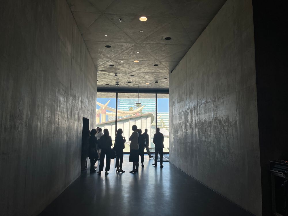 A piece of Japanese inspired architecture is visible through a hallway of concrete walls