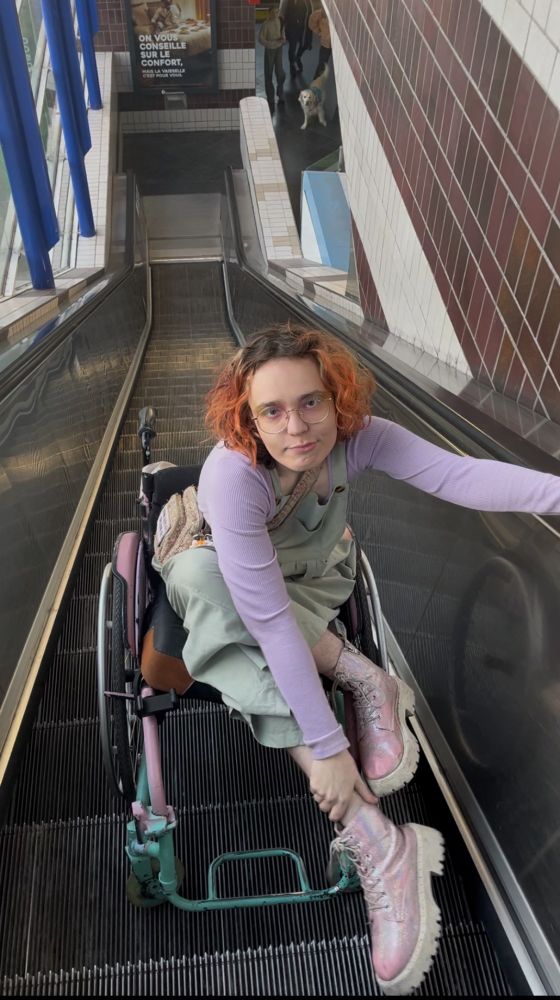Photo de Noah en fauteuil dans un escalator
