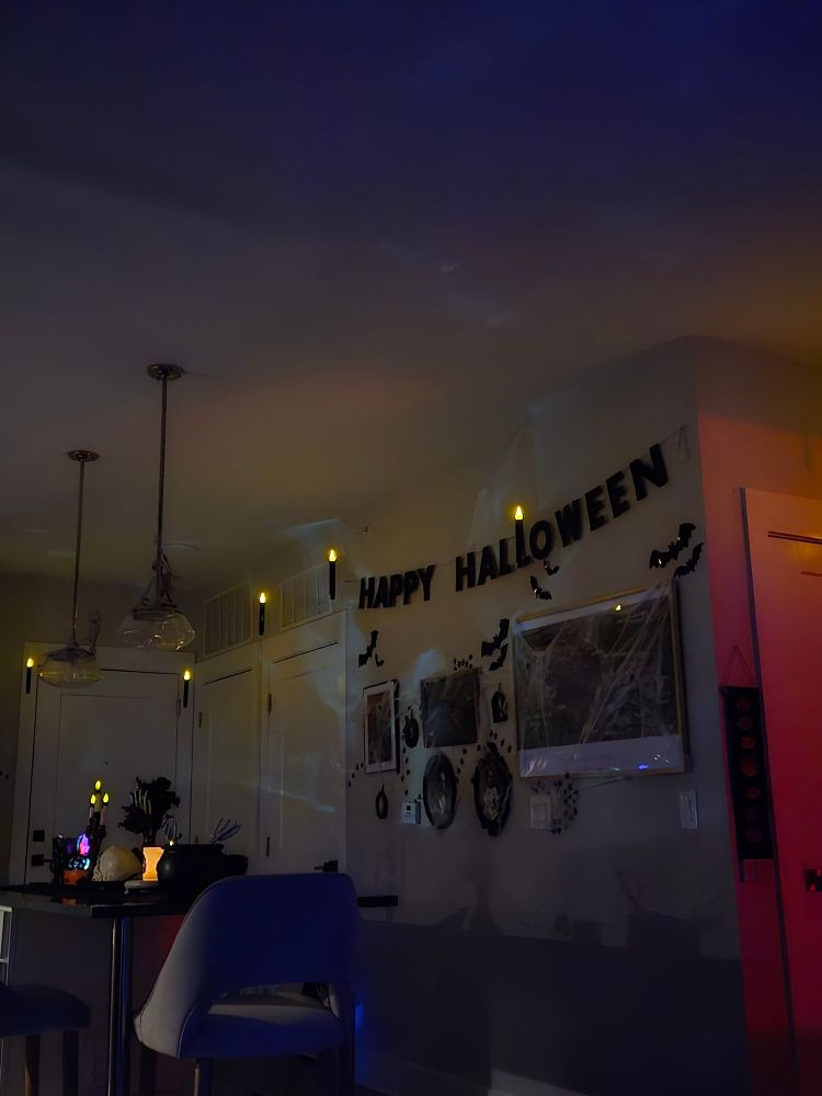 a picture of my kitchen/living with spooky decorations and floating candles on the ceiling 