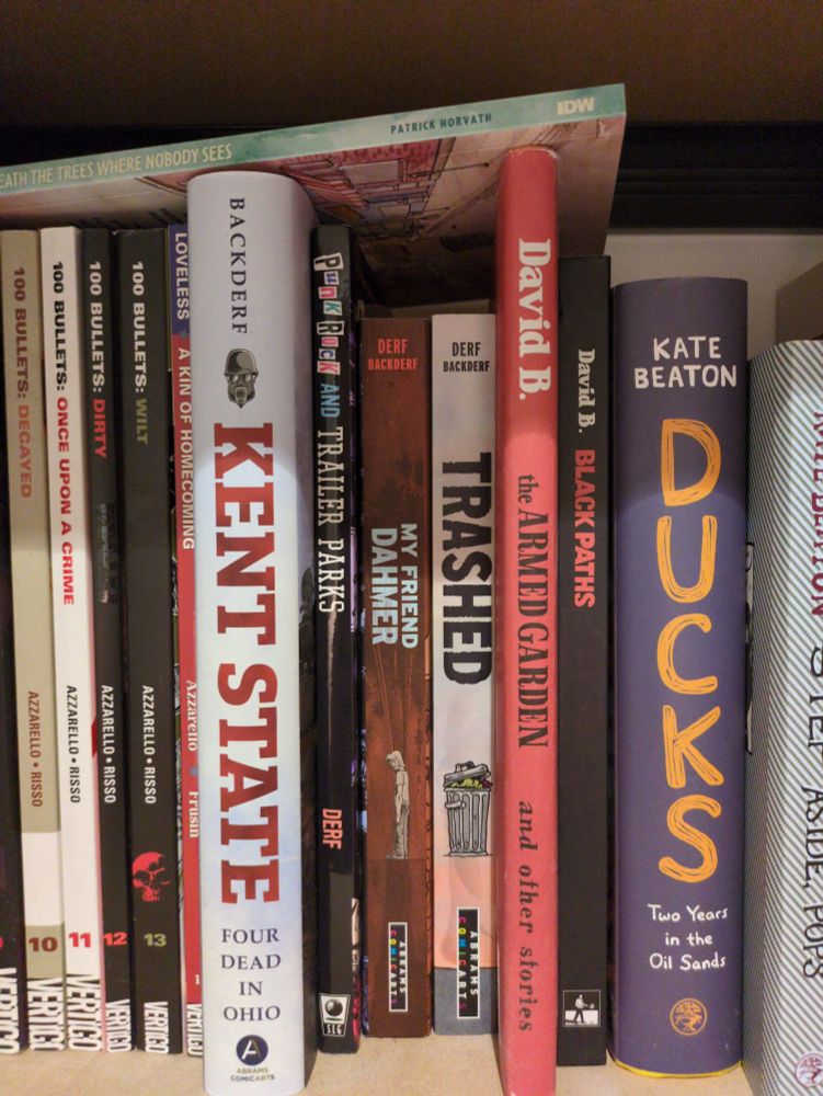 A shelf of graphic novels featuring UK editions of Derf's books