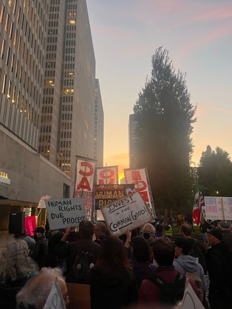 Thousands out in SF tonight for anti-ICE, anti-Trump protest. The image shows a huge crowd with signs with a setting sun in the background.