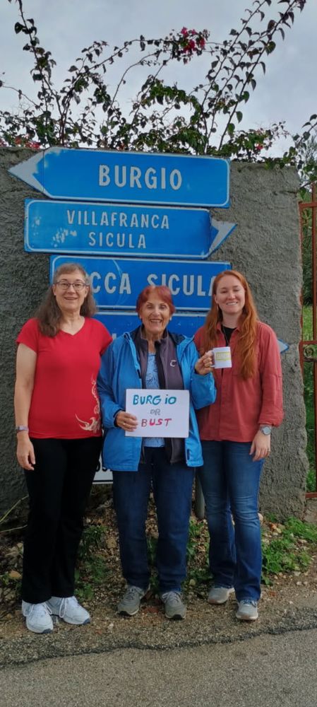 3 generations of women stand in front of the Italian city sign Burgio