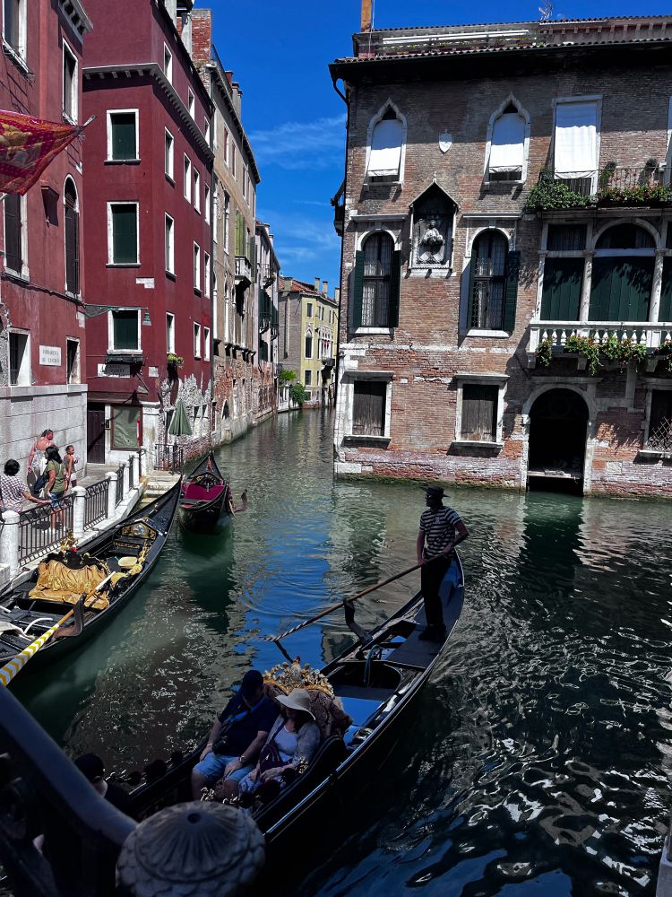 A view of a canal in Venice. There is a gondola in the photo