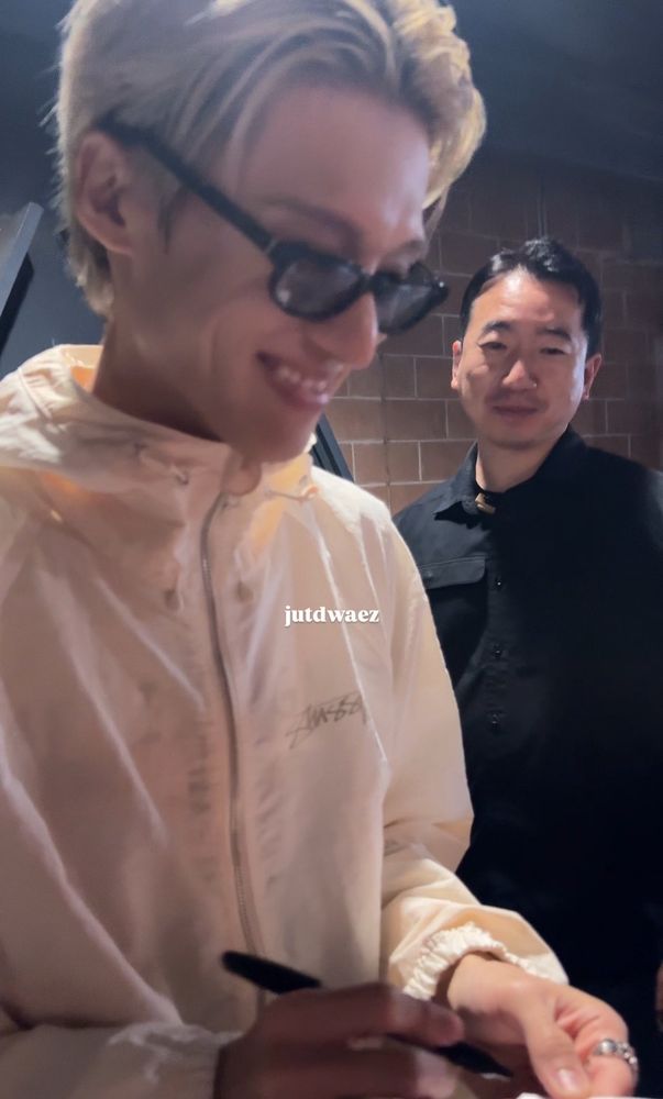 wooyoung smiling smugly as he signs 