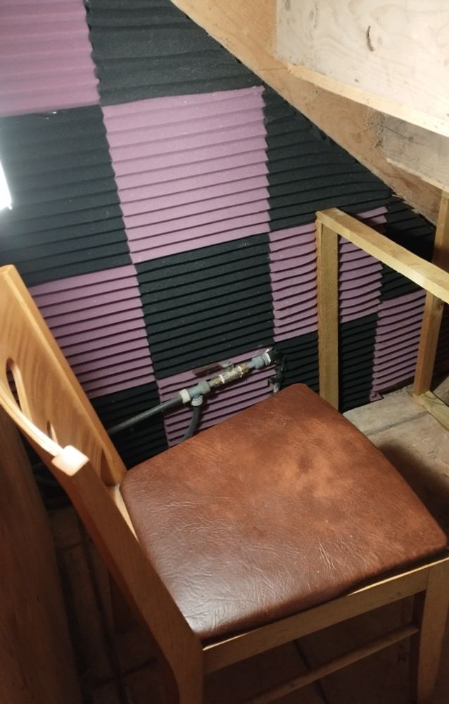 Tof's new voicework space (I'm grand with the portable - works well with my disabilities). The far wall is now lined with black & purple 1ft square tiles in fire-proofed, lightweight audio foam, & the frame for a desk is in place. A chair is temporarily in the foreground.