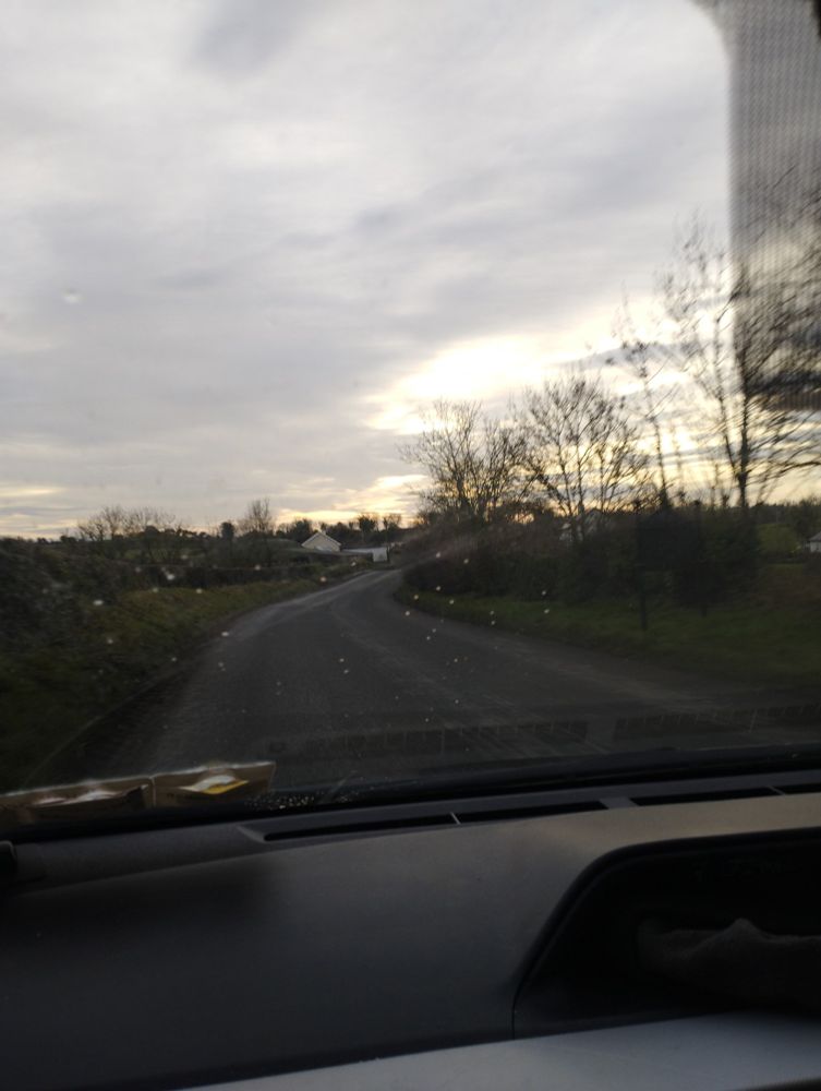Winter sunset through clouds around a bend in the road.