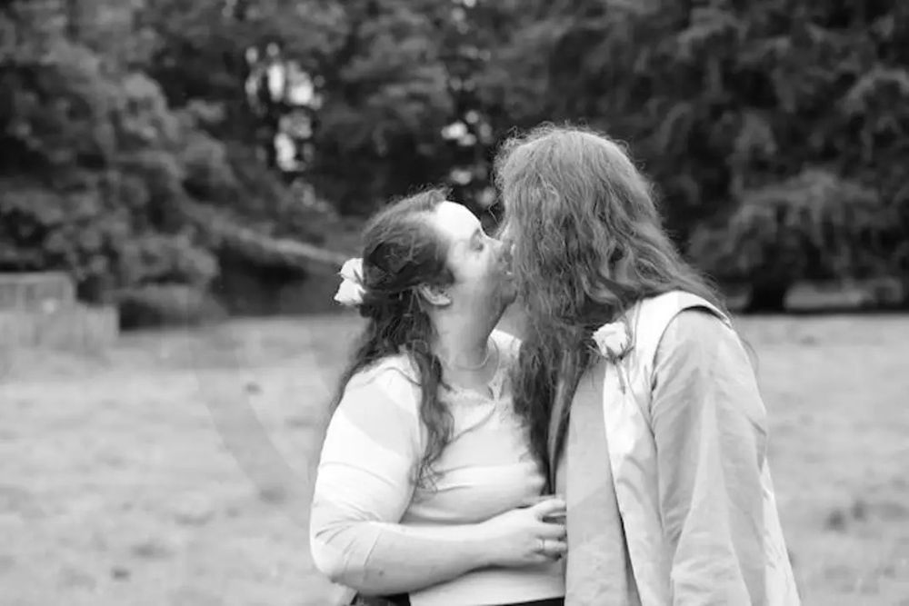 Black & white shot from our wedding of the two of us kissing in a field.