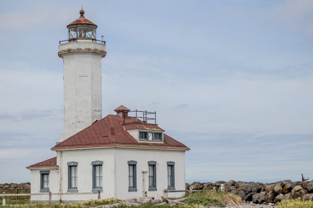 Freestanding lighthouse by levy of rocks. 