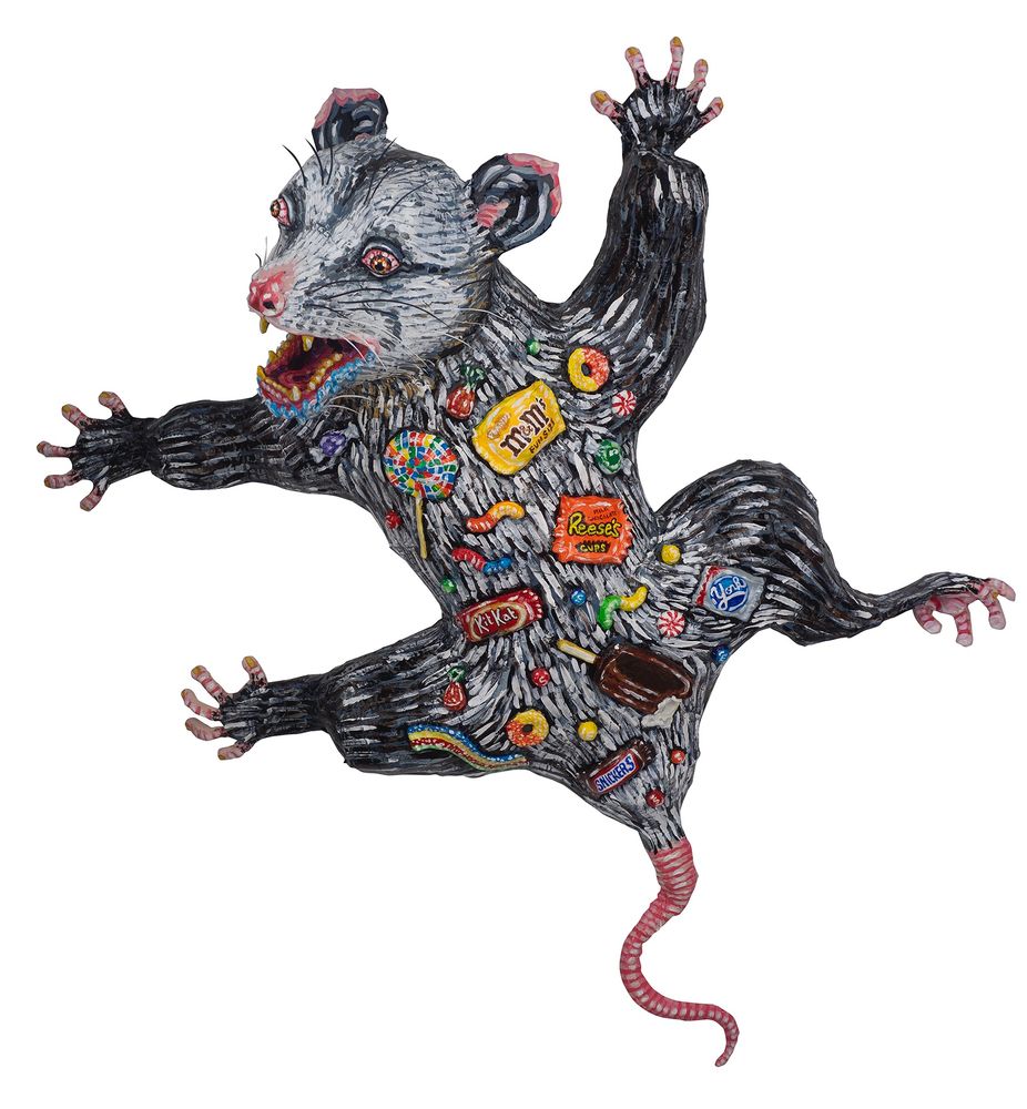 Opossum sculpture with candy on its back 
