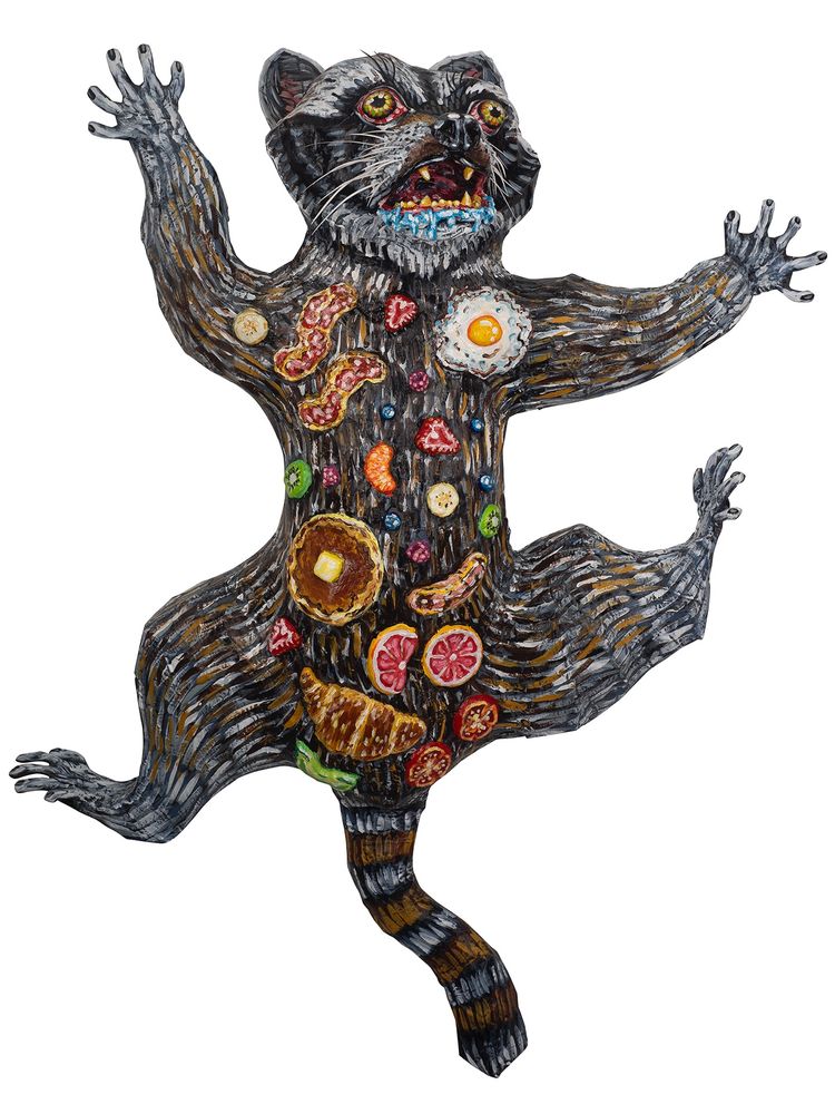 Raccoon sculpture with breakfast foods on its back 