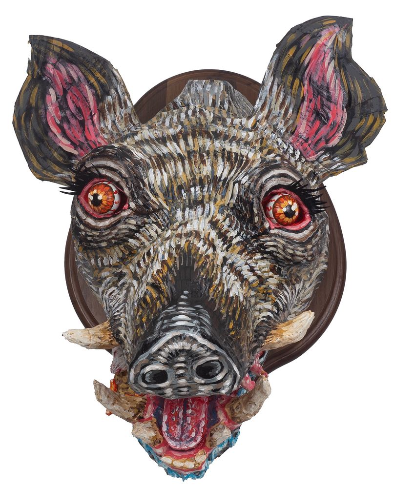 Boar head sculpture with rat and nacho in its mouth