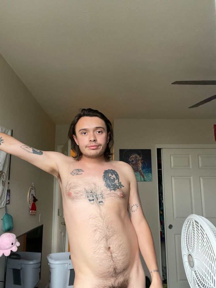 I am standing in the nude, leaning on the wall and propping myself up with my right arm. The photo is cropped just above my pubic area as I stare longingly into the camera. 