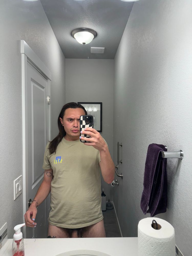 I am standing in the bathroom mirror, and my t-shirt is landing just above my bush and base of my dick, as I am standing without any pants or underwear 